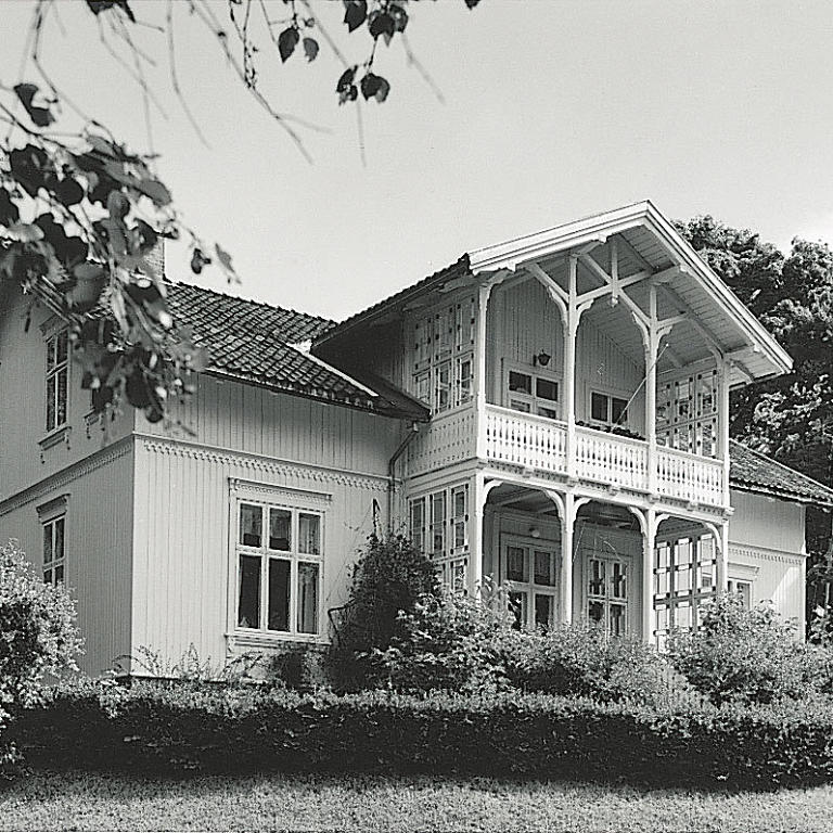 En typisk borgerlig villa fra omkring 1890. Arkitektene var på denne tiden i ferd med å forlate sveitserstilen. Det var byggmestrene som overtok, og det innebar blant annet at man gikk over til mer standardiserte former, som her i den store, symmetriske villaen med veranda. Sveitserstilens særtrekk ble beholdt, med blant annet: de store takene med synlige sperrer, bruken av gavlmotivet og sjablongpreget, utsaget dekor. Foto: Arthur Sand, IKS, Universitetet i Oslo.