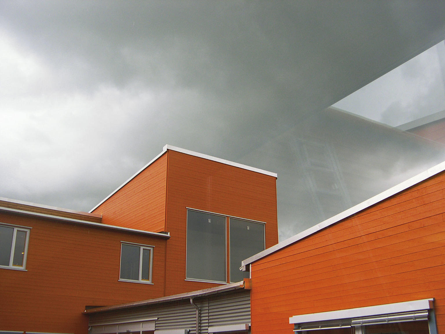 Kledning i malt trepanel knytter anlegget til området.