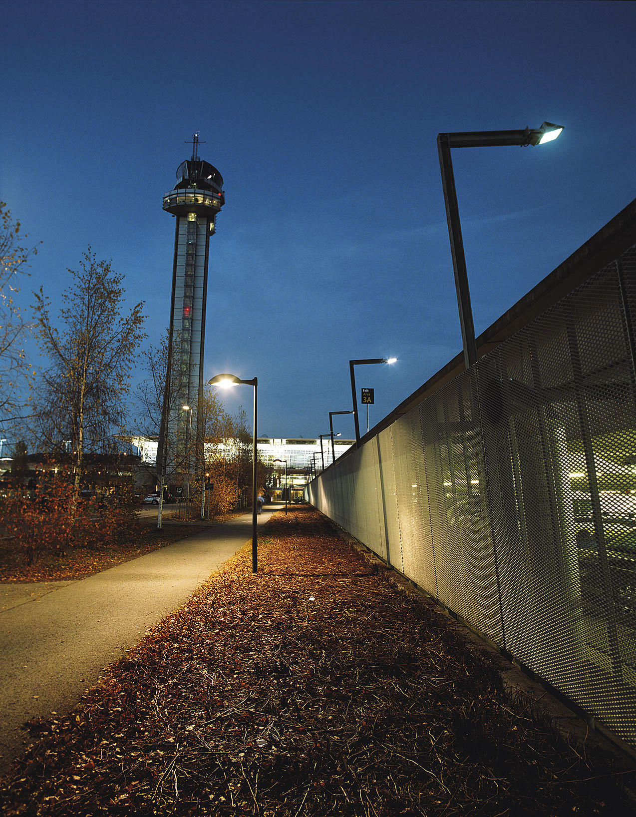 Gangvei langs P-huset. Kontrolltårnet og terminalbygningen bak. Foto: Ivan Brodey