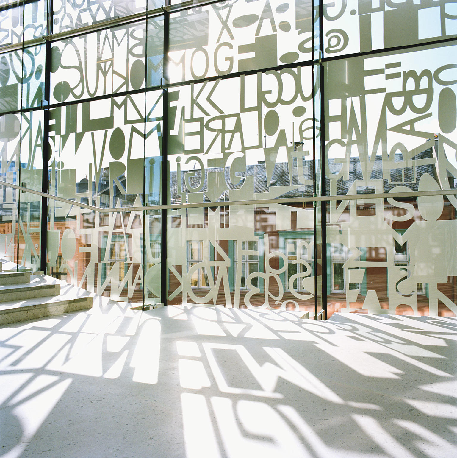 Utsmykningen av hovedfasaden fungerer også som solavskjerming. Fra trappereposet ut mot Osterhaus gate. Utsmykning ved Jorunn Sannes.