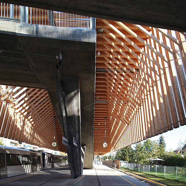 Den nedhengte trekonstruksjonen gir ly både for rampen og perrongen under.