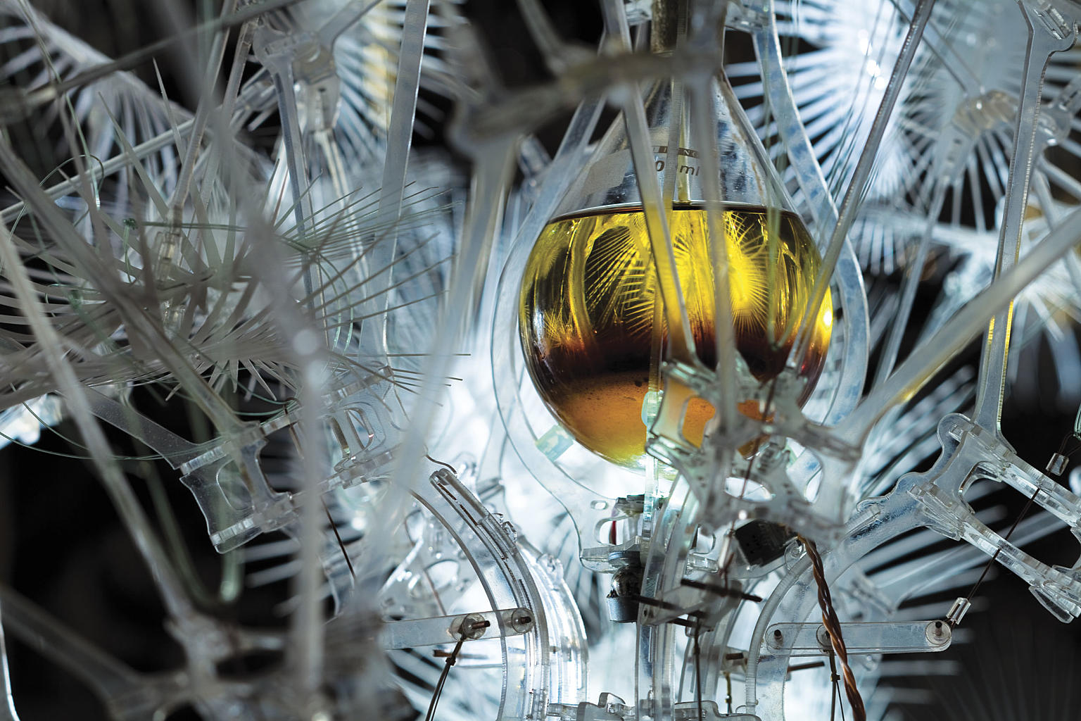 En av Rachel Armstrongs “protoceller”, en liten kolbe med salter i oppløsning, som reagerer kjemisk på tilstedeværelsen av besøkende. De små økningene av CO2 i lufta setter i gang reaksjoner som synliggjøres i andre deler av systemet, som farge eller bevegelse.