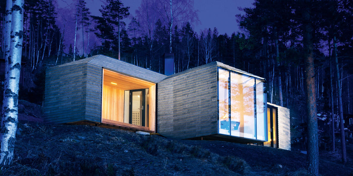 Hytta sett fra atkomstveien, glassfasaden åpner seg mot utsikten.