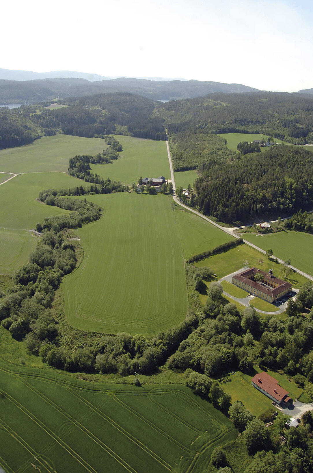 Flyfoto av Falstadlandskapet, med Falstadbygningen og kommandantboligen i forgrunnen. Foto: Falstadsenteret