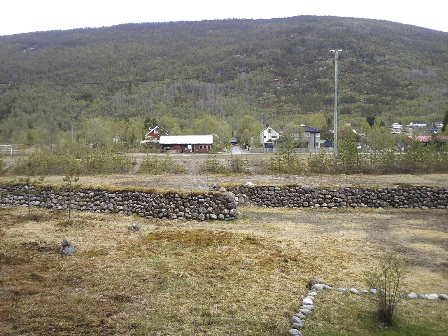 Beisfjord 2011. Natursteinsmur, fotballbane mellom muren og husene. Bildet er tatt i samme retning som ovenfor. Foto: Michael Stokke, Narviksenteret