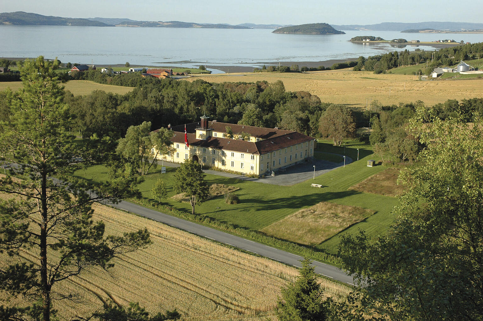 Falstadbygningen i 2009. Brakkefundamentene er markert med vegetasjon. Foto: ADS