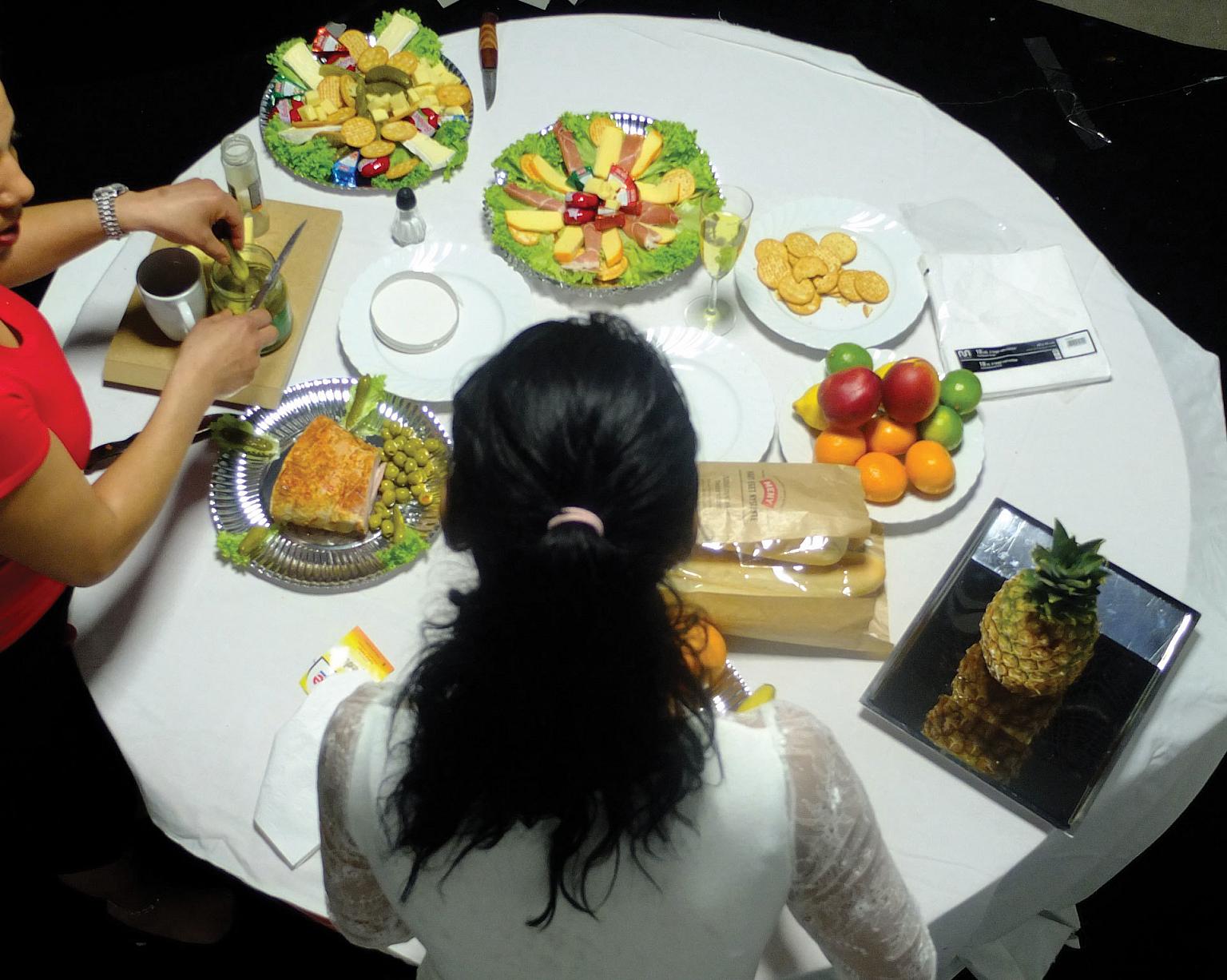 Romni forbereder mat som borddekort til bryllupsfest. Møtene rundt bordet filmes, og blir en del av installasjonen i den ferdige utstillingen. Foto: Fredrik Birkelund