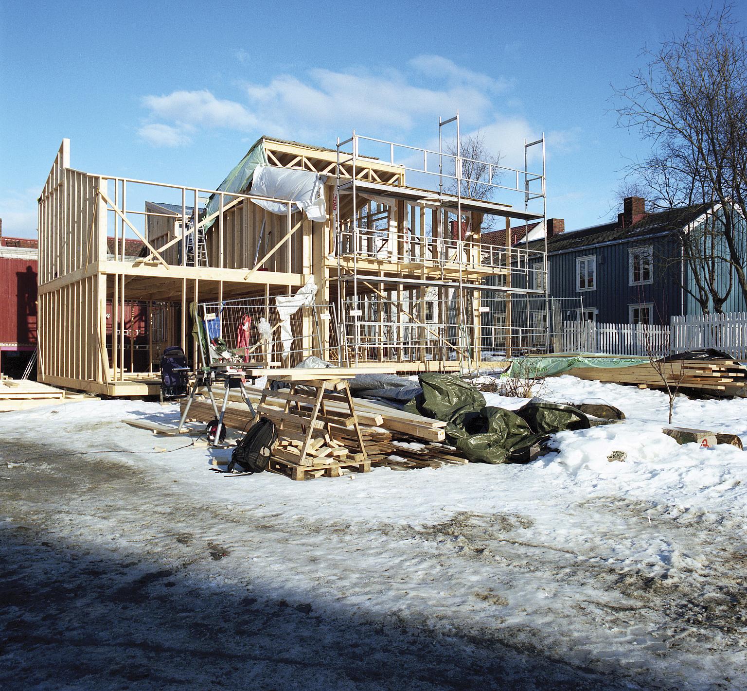 Hus 1 og 2, mars 2016. Felleshuset skimtes gjennom reisverket i bakgrunnen. Foto: Vigdis Haugtrø