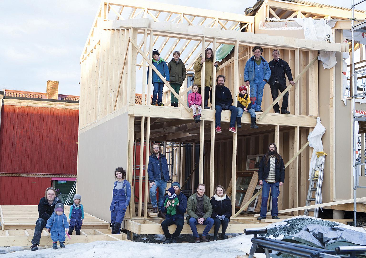 Selvbyggergruppen. Nederst fra venstre: John Strandskog, Linus og Leoni (barn til Guro og John), Guro Sletnes (Hus 1), Per-Kristian Nygård (Hus 3), Trygve Ohren med sin sønn Bastian på fanget, Haakon Haanes og Cathrine Johansen Rønningen (Nøysom arkitekter), Markus Lantto (Hus 4). Øverst fra venstre: Johannes (Iacobs sønn), Vidar (Markus’ sønn), Eldrid, Siri Gjære, Torfinn Borkhus og Sivert (Hus 5), Iacob Sømme (Hus 2) og Arnleiv Overgård (byggmester ansatt av Svartlamon boligstiftelse). Foto: Vigdis Haugtrø