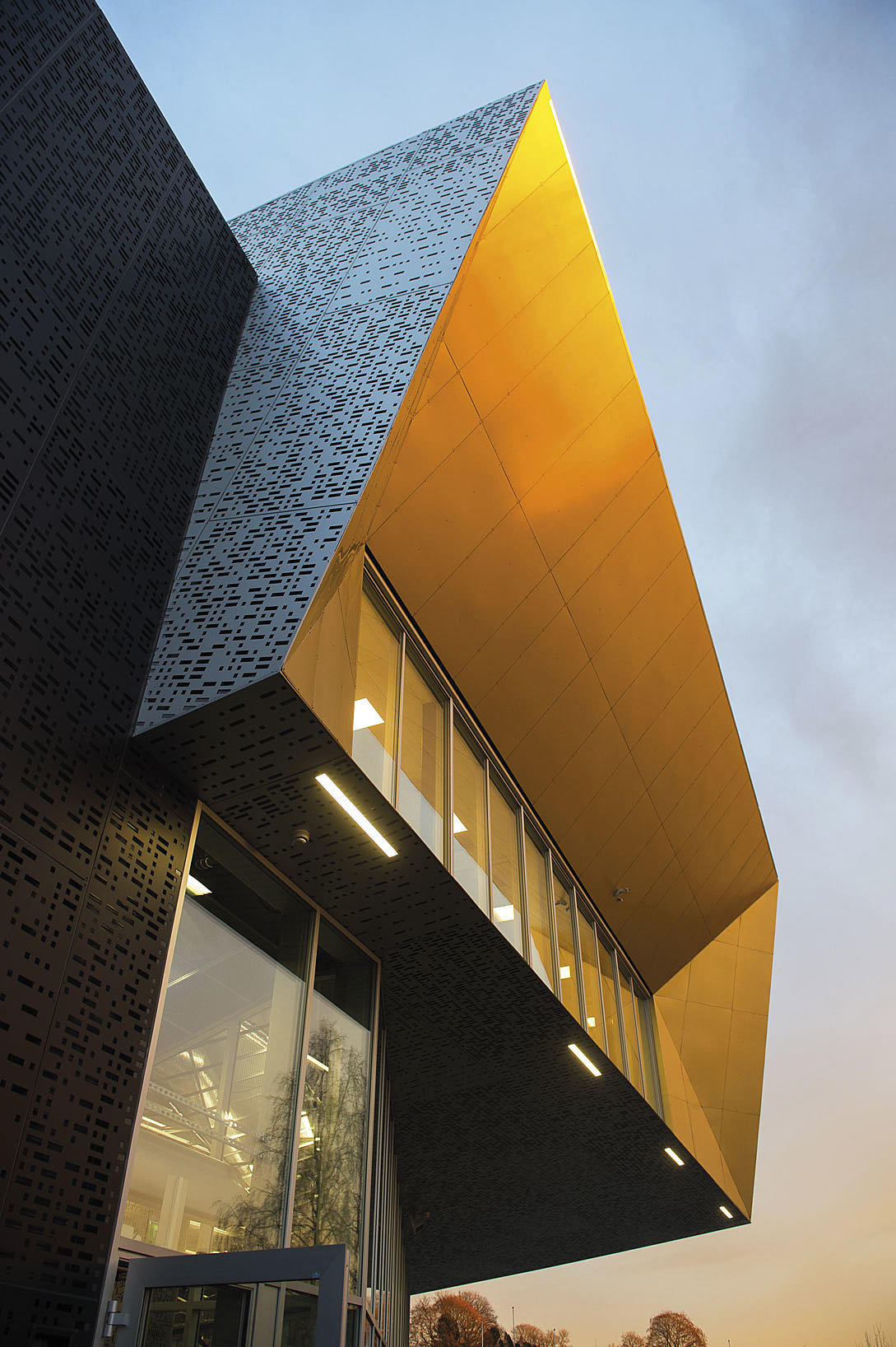 Fra adkomstfasaden mot vest. Skatehallen er utformet som to motstående volumer, ett lyst og ett mørkt, som åpner seg i hver sin retning mot vest og øst.