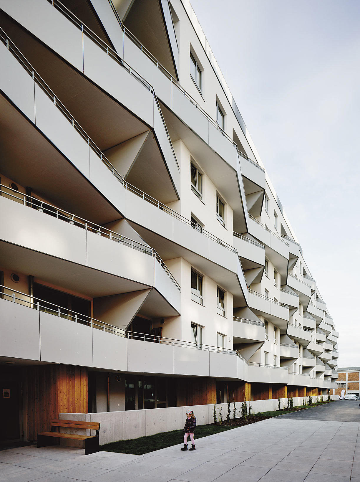 Vertikalt nabolag. Lamellens zig-zag-fasade. Duplex-leiligheter på bakkeplan/2. etasje.