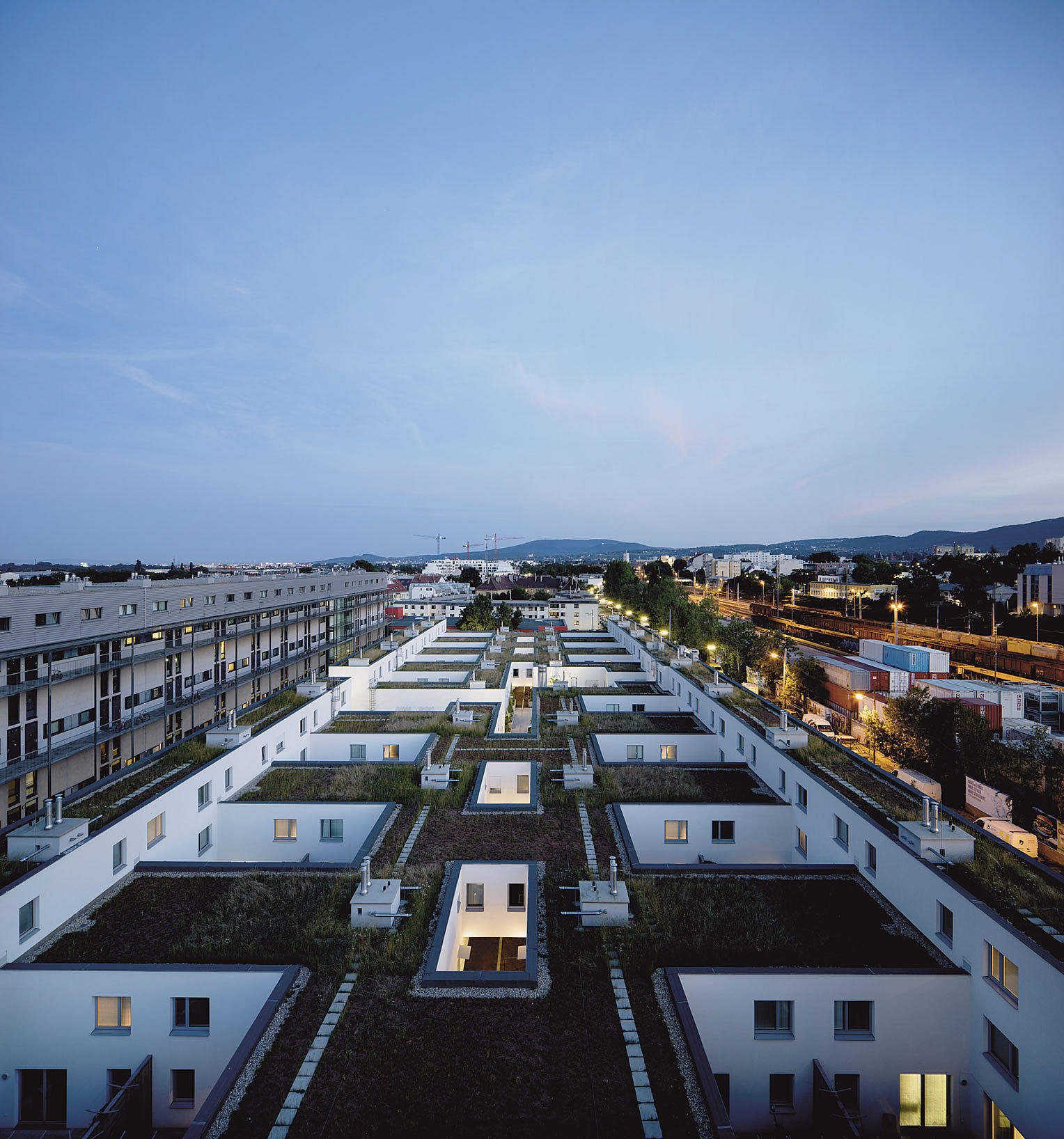 No sentimentality! Boligteppet med atriumhusene sett fra lamellens bassengdekk. Introvert boligstruktur konfronterer byen. Tomten er brutal og uten forutsigbar kvalitet.