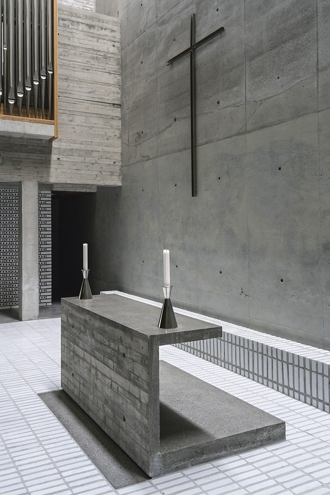 Clerusbenk i betong: Podium og alter er erstattet av en «clerusbenk» støpt på et gulv av hvitglasert tegl. «Alterstålet» er tegnet av Aina Dahle.