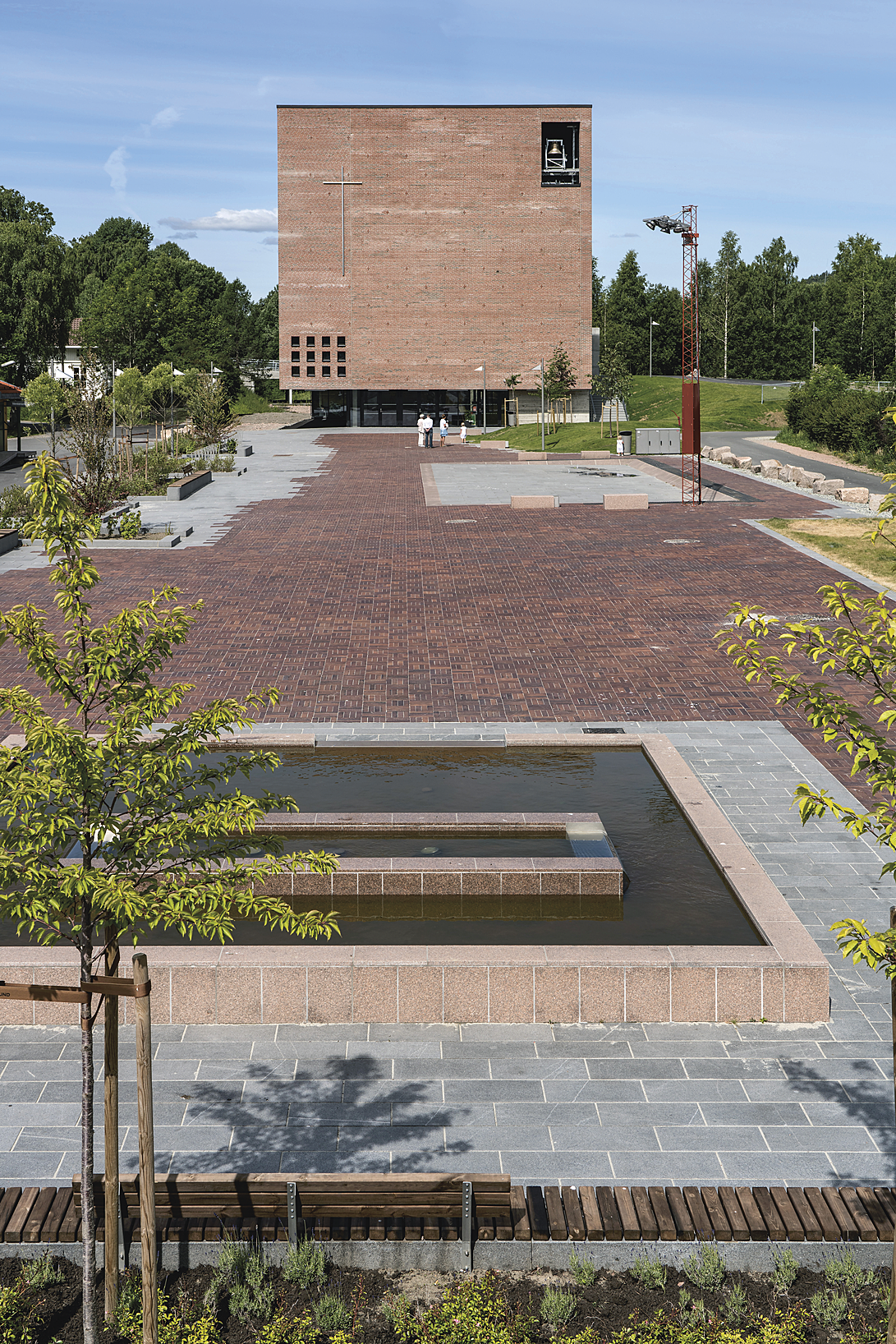 Spikkestad torg: Teglteppet på Spikkestad torg er tatt opp i fasaden mot stasjonen, med umiskjennelige religiøse symboler på det fortolkede kirketårnet.