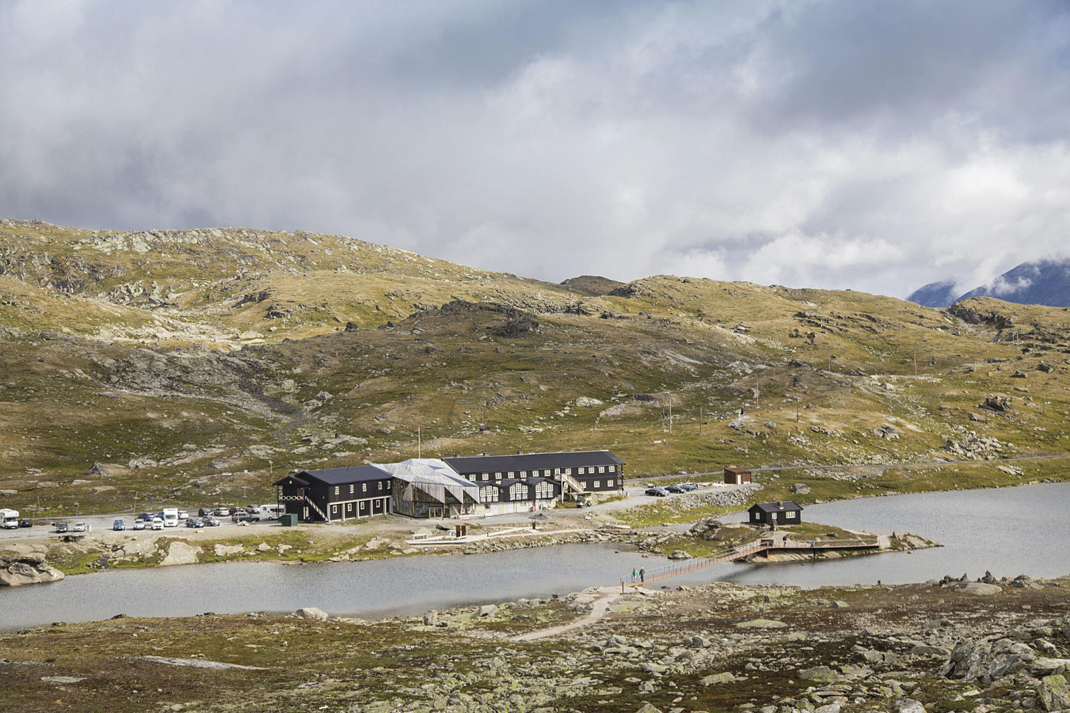 Sognefjellshytta er utgangspunktet for turstien. Turstien har en farge og materialpallett som gjør at den glir inn i omgivelsene.
