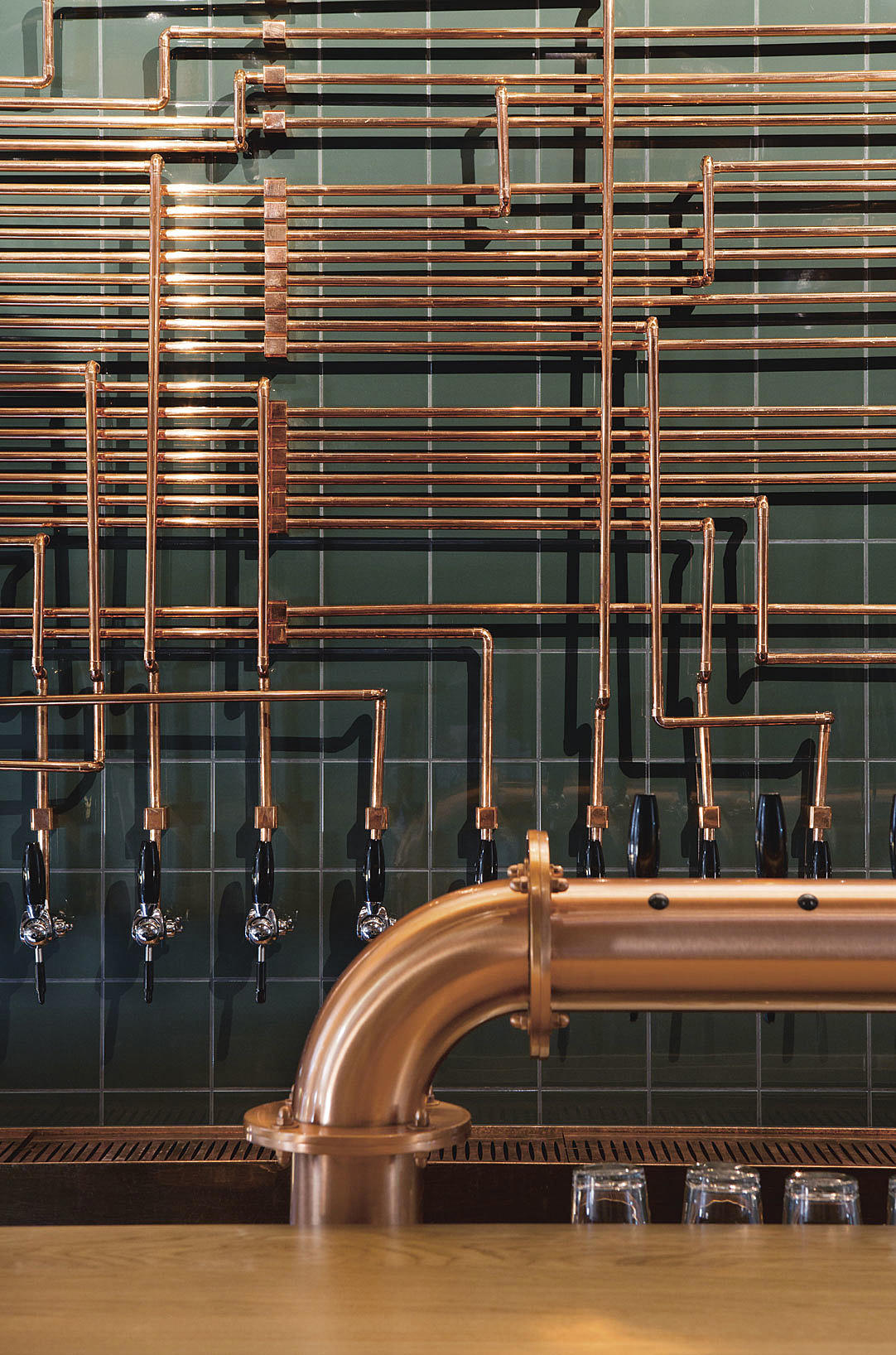 Utsmykning med rørene til tappekranene på bakveggen i baren.