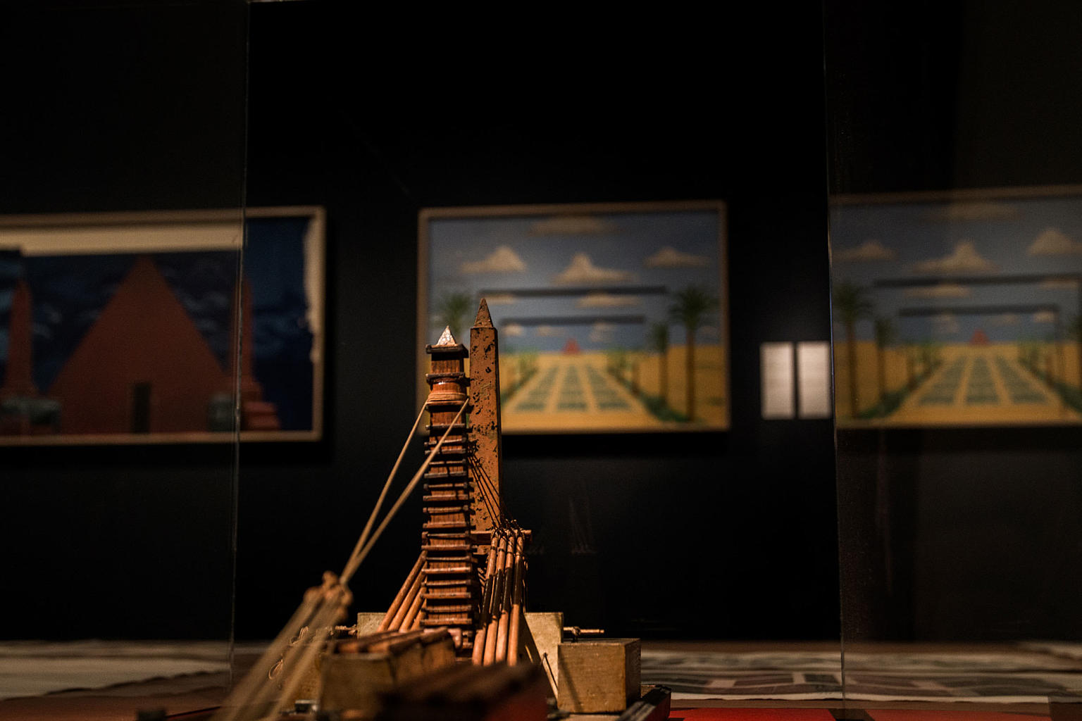 Fra Images of Egypt: Marine-ingeniør Appolinaire Lebas’ originale modell av innretningen han anvendte for å senke Luxor-obelisken i 1831, utstilt på en gigantisk divan i galleriet blant to førsteutgaver av Description de l’Égypte (1809), og en rekke uinnbundne blad fra samme verk. I bakgrunnen, på veggen: To av David Hockneys sceneografier for Mozarts Tryllefløyten (1977). Et prosjekt av OCCAS, The Oslo Centre for Critical Architectural Studies. Foto: Eirik Bøhn.