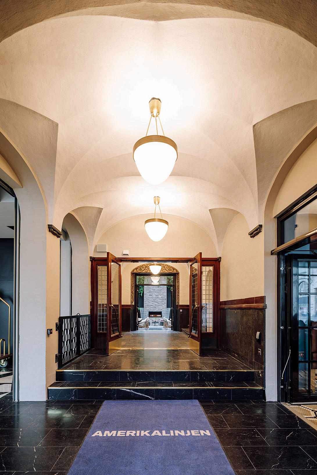 Gangarealene på bakkeplan og trappeløpene oppover i etasjene er ført tilbake til original stand og fremstår som et av de aller flotteste enkeltelementene i det nye hotellet. På bildet ser man inn mot den klimatiserte bakgården.