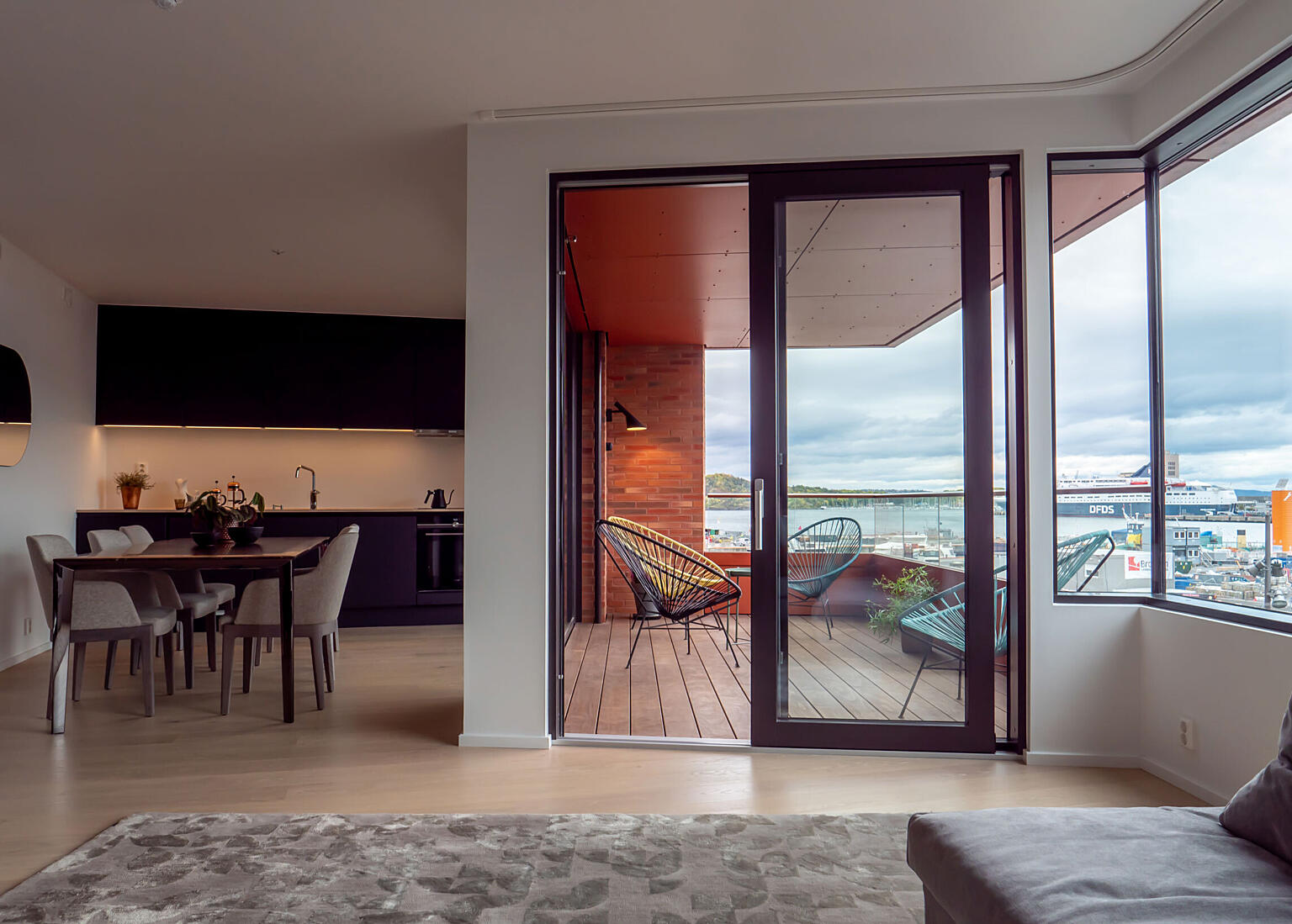 Hjørnevindu og høye glassfelt mot loggiabalkong gir både gode dagslysforhold og fantastisk utsikt fra oppholdsrom mot fjordbassenget. Balkongbrystningenenes utforming gir private uterom både skjerming og utsyn.