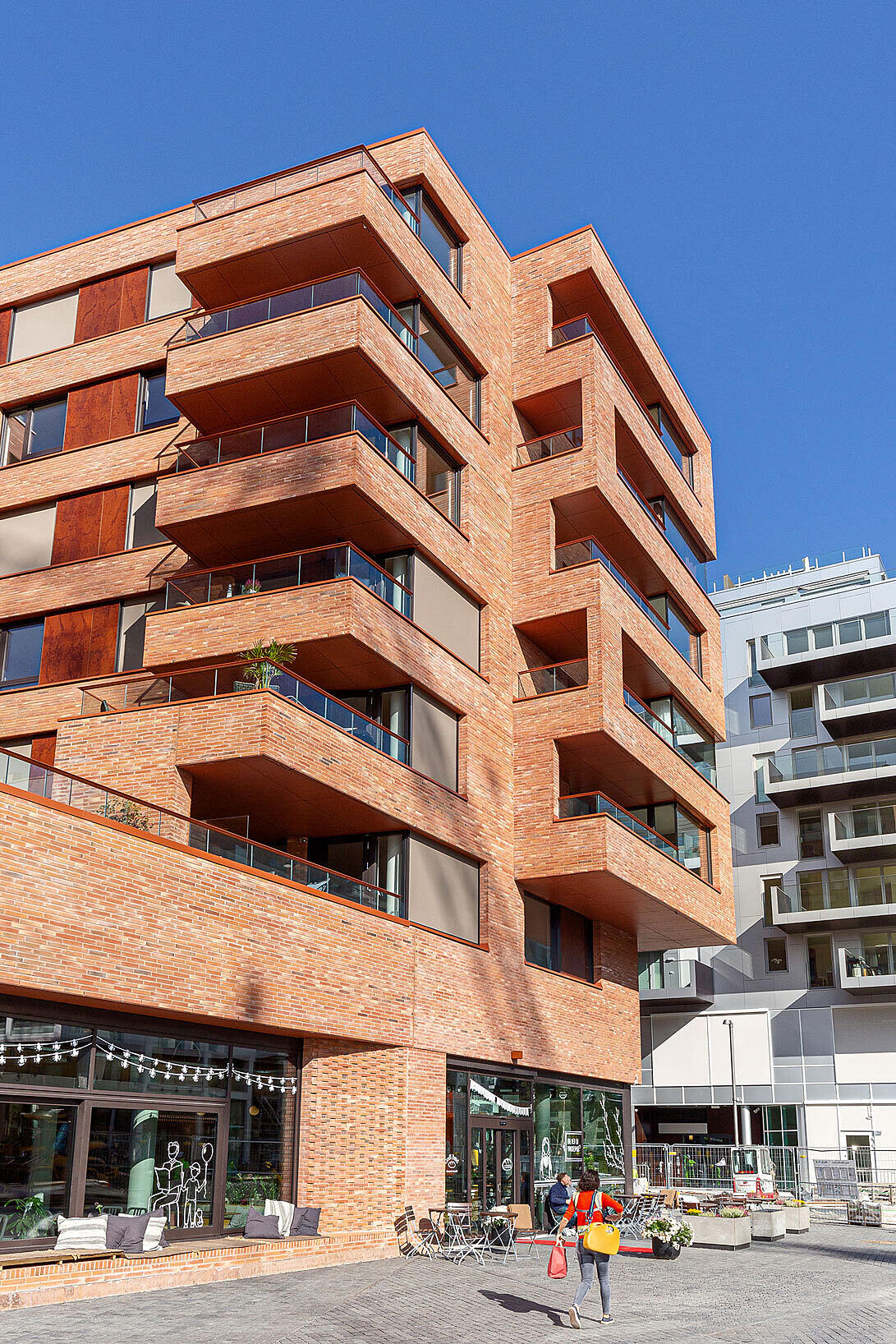 Barnehagens uteareal over forretninger og restauranter i kvartalets base, har utsyn ned mot Stasjonsalmenningen. På bakkeplan tilbyr dype vindusnisjer skjermede sitteplasser.