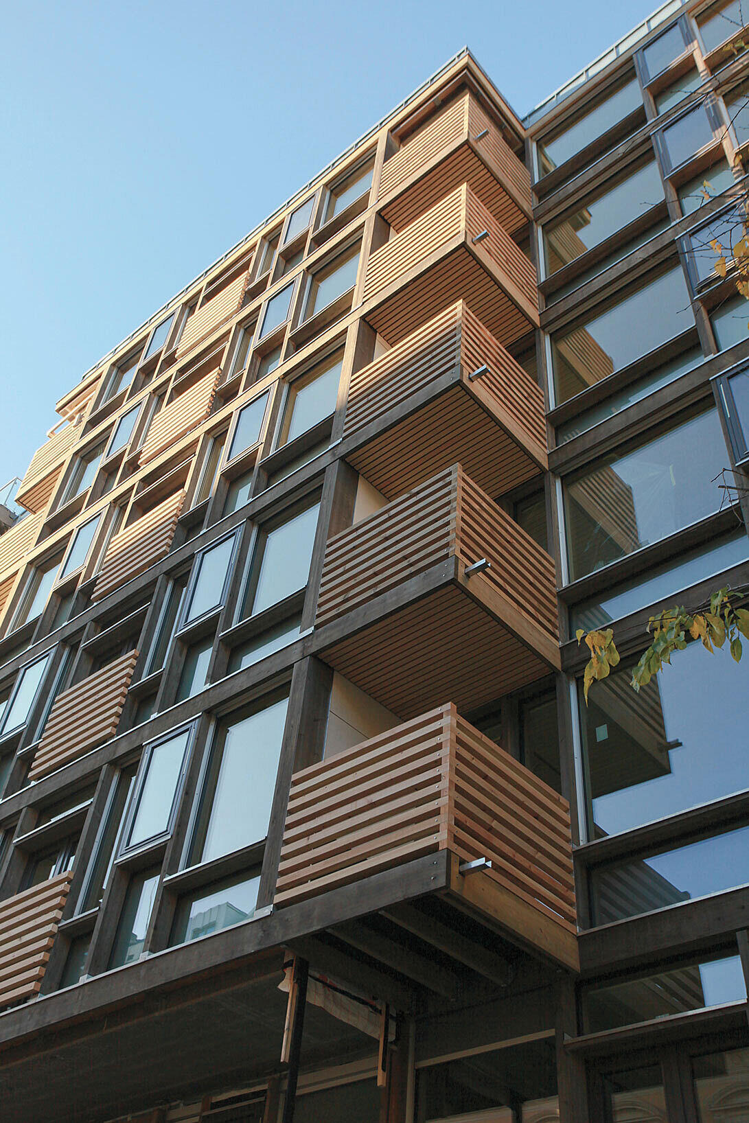 Huitfeldts gate 15. Fasaden er bygget med prefabrikkerte elementer av renskåret furu kjerneved. Harpiksen beskytter mot nedbryting og elementene er ikke oveflatebehandlet, men all endeved er grundig forseglet mot van Foto: JSA Arkitekter.