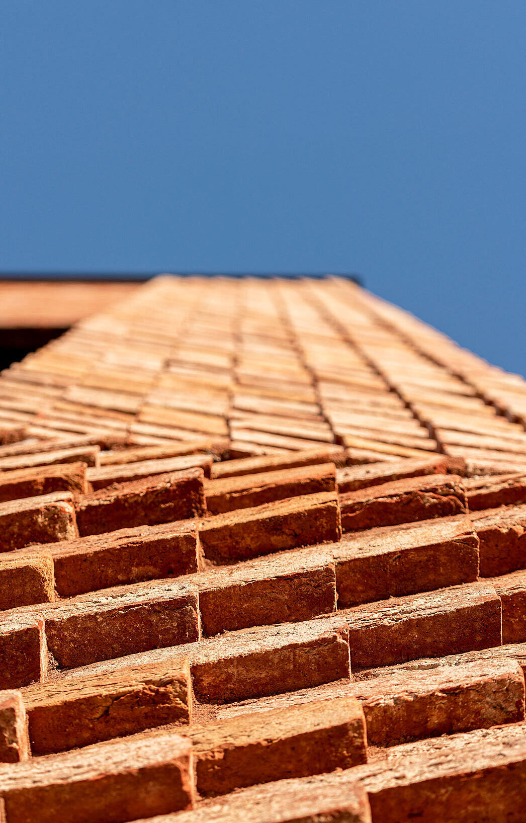 De presise murarbeidene og valget av tegl gir fasaden særpreg samtidig som motivet med pilastre gir klare assosiasjoner til klassisk universitetsarkitektur.