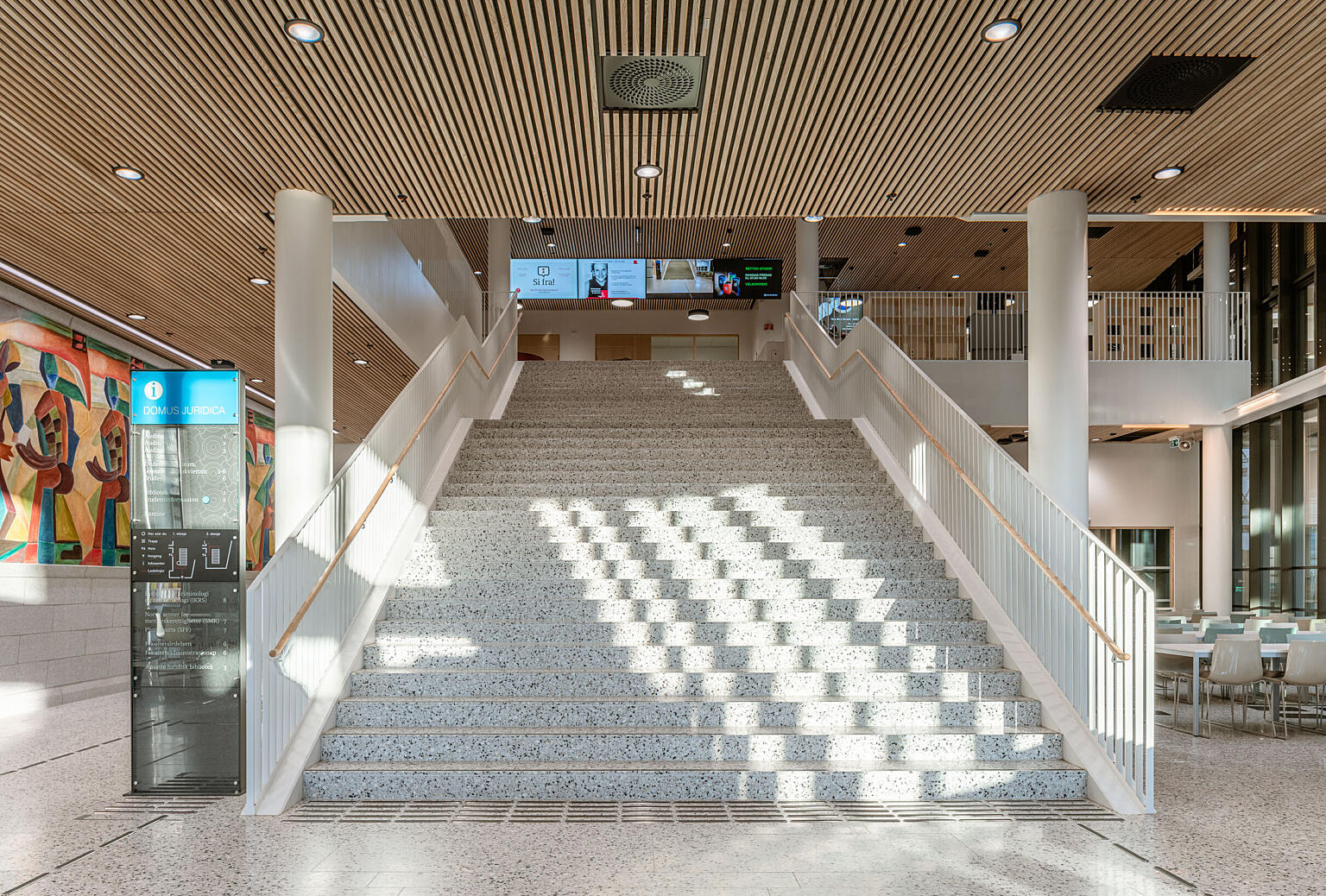 Trappen opptar mye av plassen i den relativt lille hallen i første etasje av bygningen. Kantinen er med vilje underdimensjonert slik at studentene skal tvinges til å bruke byen utenfor.