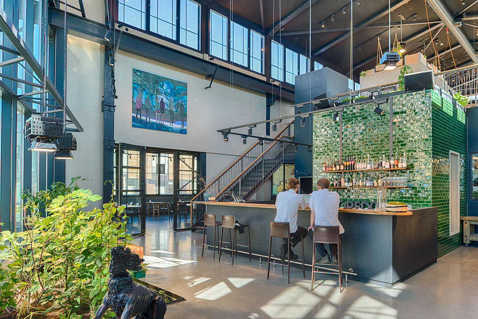 Gløtt fra baren inn i CREDO-lokalet i nordre sideskip. Glassdørene er tegnet av arkitektene og produsert av en lokal smed.