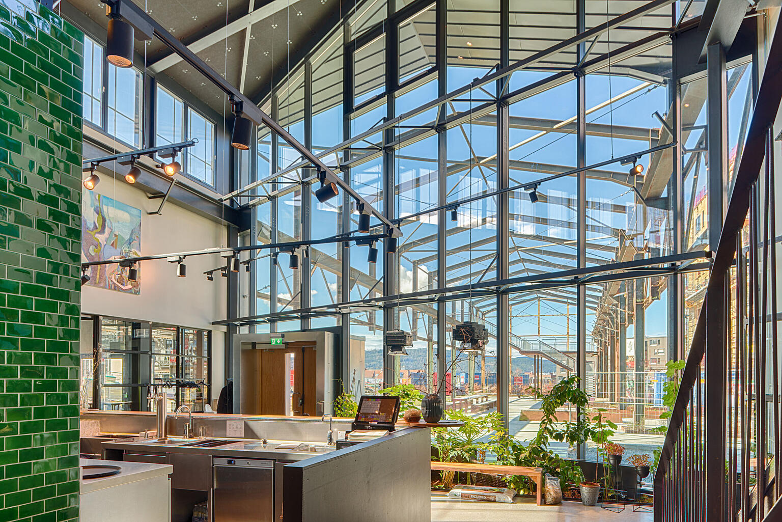 Den skrå glassveggen krysser en tidligere smøregrav som fungerer som plantefelt med spiselige vekster både ute og inne. Utvendig er strukturen transformert til uteområdet Maskinparken av landskapsarkitektene Asplan Viak.