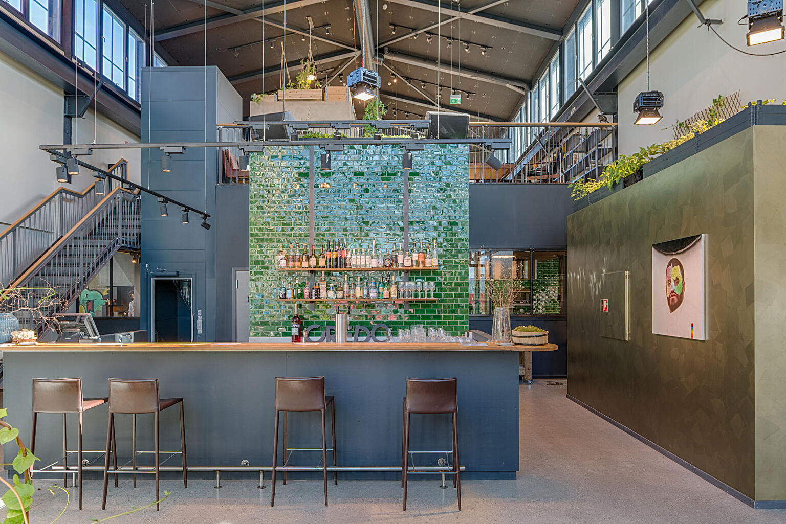 Hovedinngang med bar og vinlager ligger i midtskipet med gjennomlys og kontakt opp til messaninen og gløtt inn til kjøkkenet.