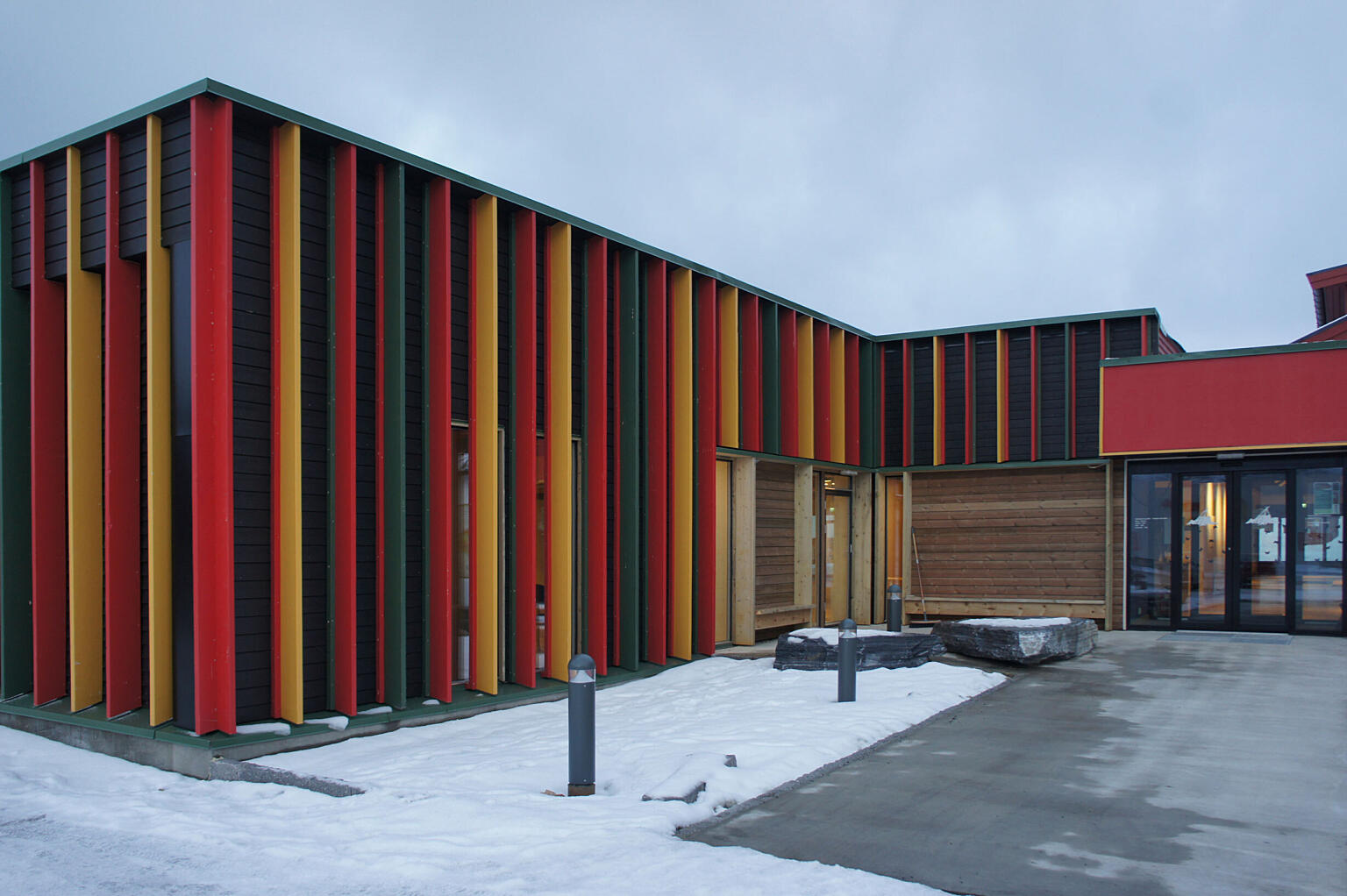 Uteplassen utenfor inngangen til senteret er utformet med lave utelamper og sittebenker innfelt i fasaden. Til våren skal det plantes bjørketrær i lokal skjellsand. Foto: Astrid Fadnes