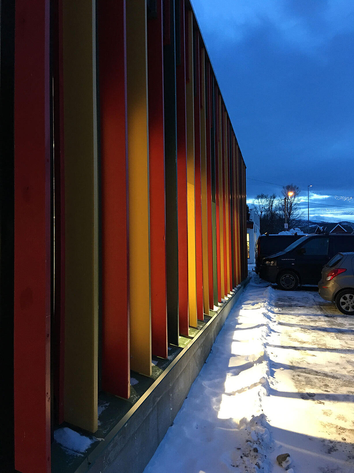 Opprinnelig ville arkitekten ha en ren glassfasade, for å synliggjøre innendørs aktivitet ut til gata. Det ble for dyrt, og løsningen ble å male den opprinnelige fasaden svart og skru spiler fast i kledningen. Fargene er hentet fra den lokale gáktien, kofta Foto: Code arkitektur