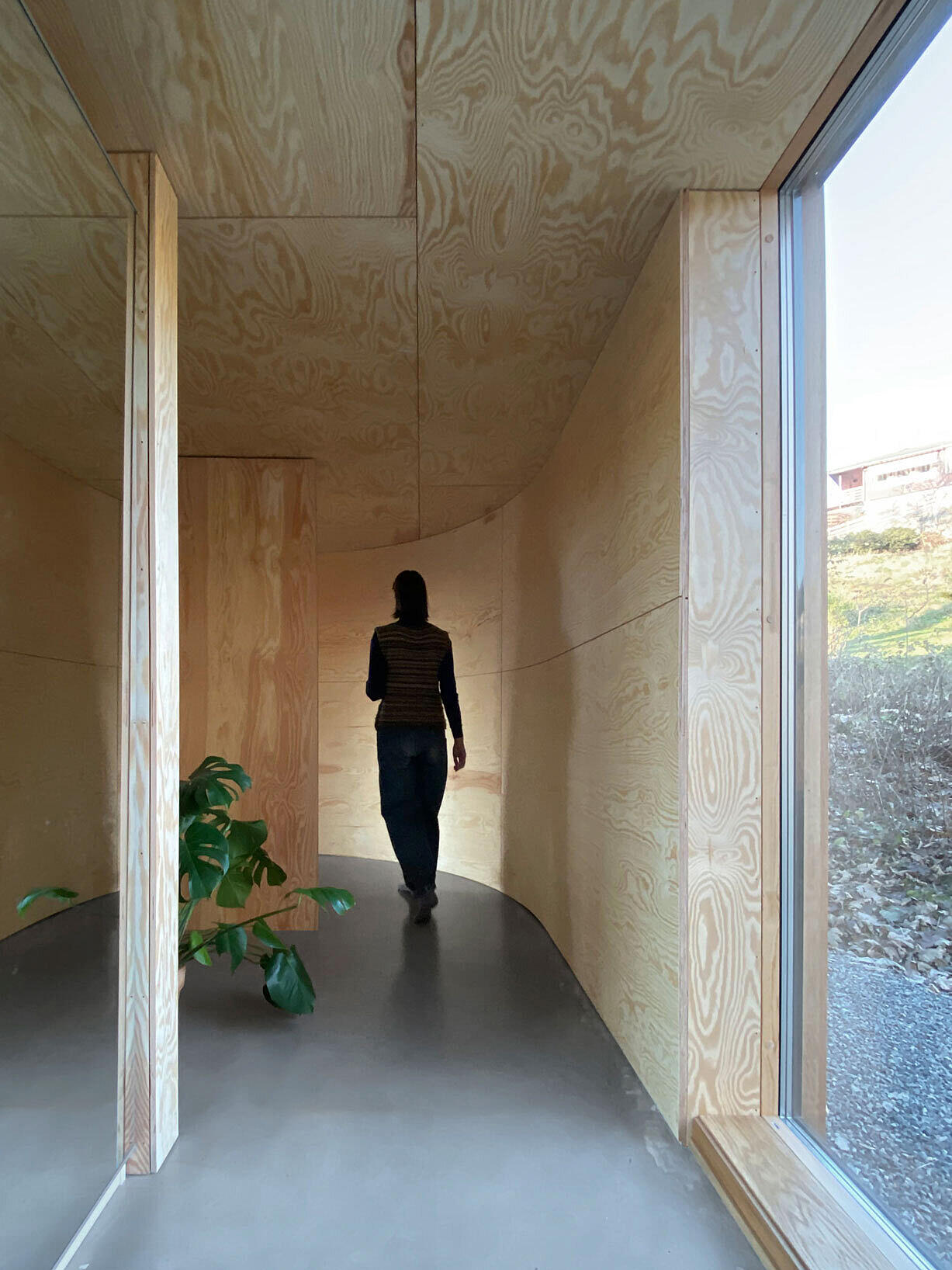 Alt er nedtonet. Eller vent nå litt … Eksteriøret er dempet og nøkternt, men inngangspartiet er anlagt som en buet detalj som beriker både romforløpet innendørs og opplevelsen av interiøret.